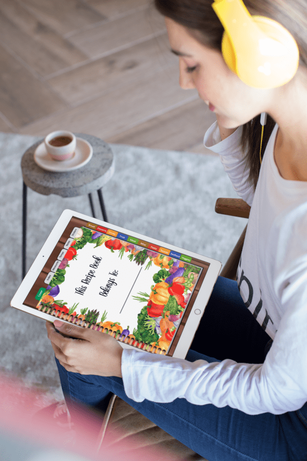 Woman-holding-tablet-looking-at-recipe-book-journal